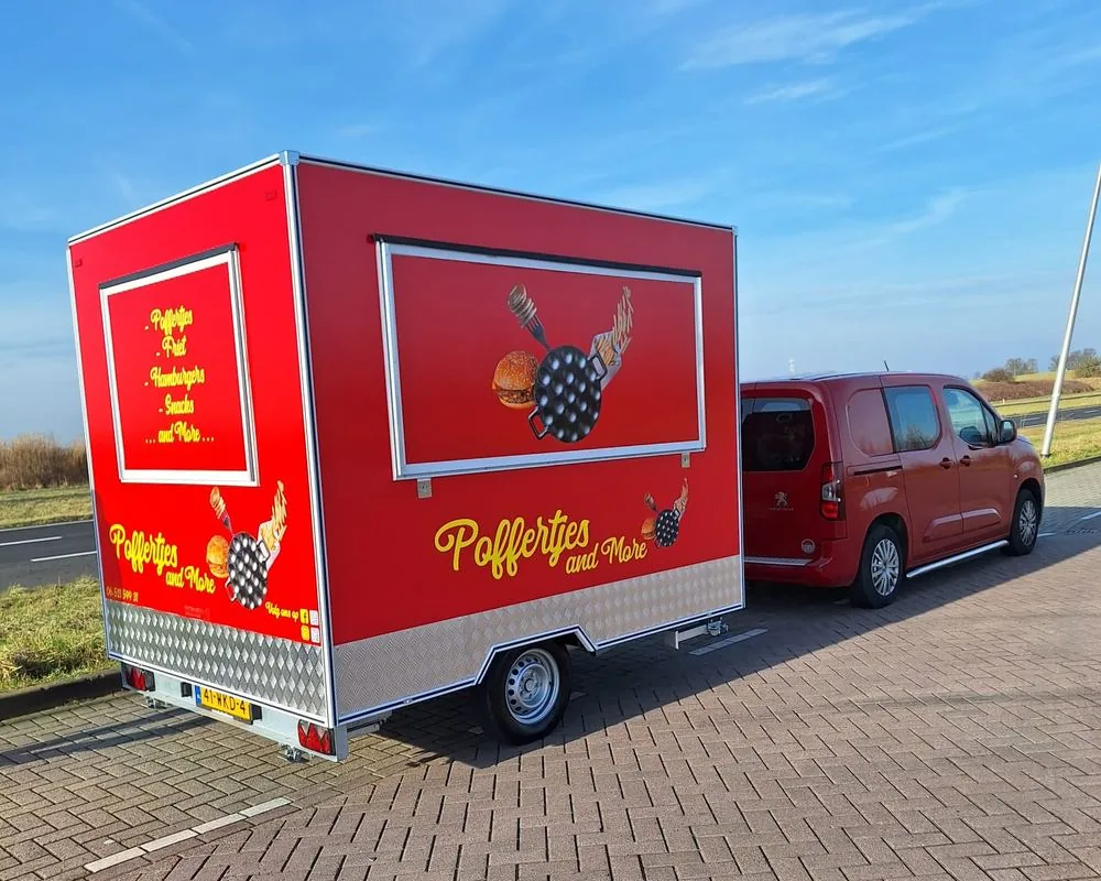De rode foodtruck van Poffertjes and More onderweg naar een feest