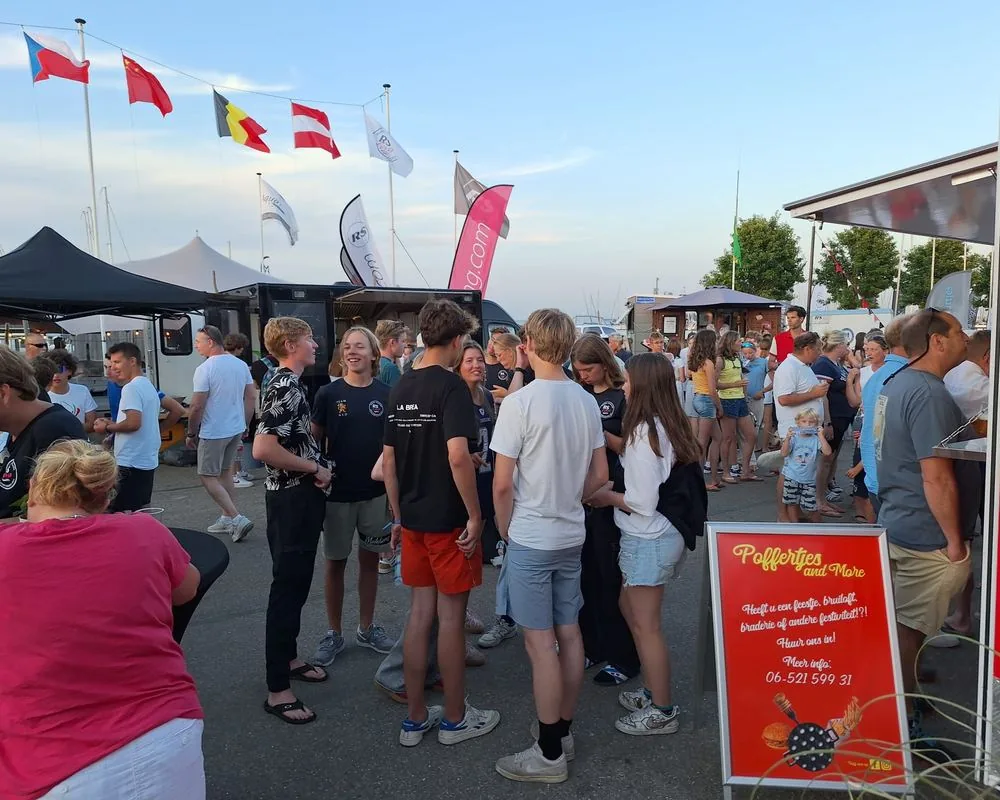 Drukte bij de foodtruck van Poffertjes and More tijdens een zeilevenement in de haven